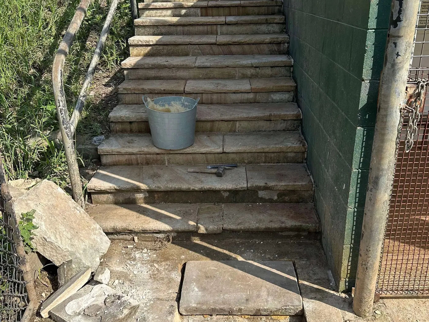 Sandstone stair restoration beside an existing structure